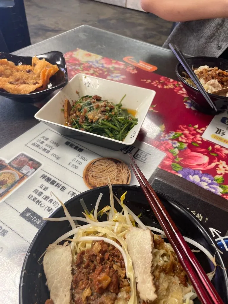 桌上的乾意麵、炸餛飩,和淋了肉燥的燙青菜
